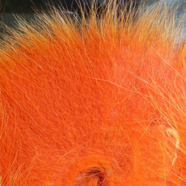 Close up of dyed hot orange arctic fox tail fur used for fly tying.