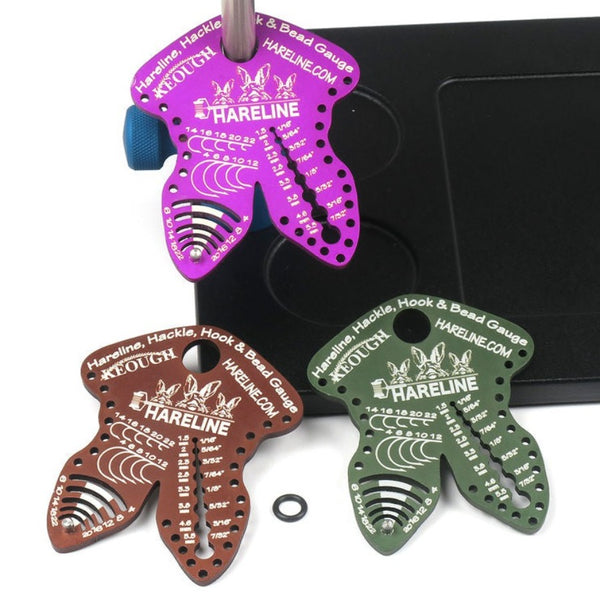 3 hareline hook hackle bead gauges of different colors with vise base and post on white background
