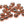 A large group of copper cyclops tungsten beads for fly tying on a white background.