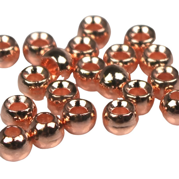 A large group of copper cyclops tungsten beads for fly tying on a white background.