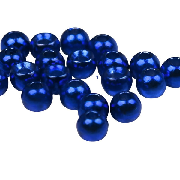 A large group of metallic blue cyclops tungsten beads for fly tying on a white background.