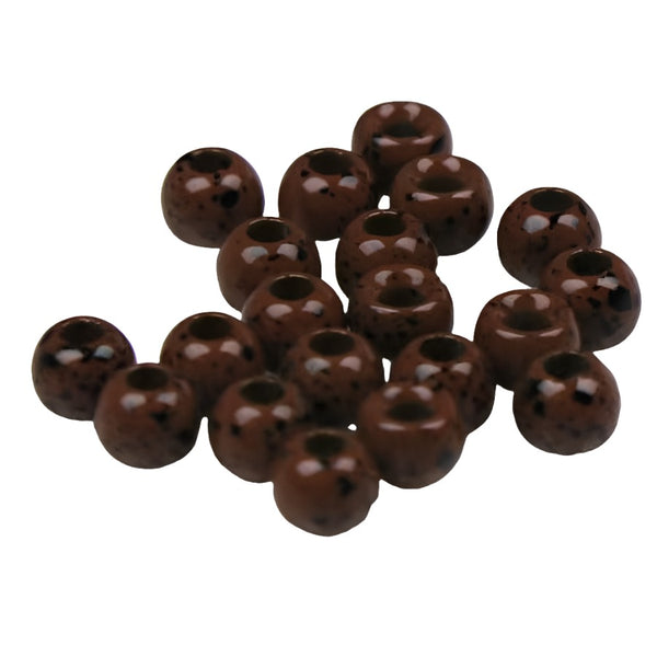 A large group of mottled brown cyclops tungsten beads for fly tying on a white background.