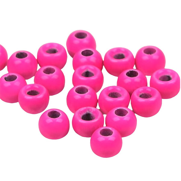 A large group of pink cyclops tungsten beads for fly tying on a white background.