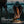 Person tying shoelaces with a Nebo Mycro headlamp on a ballcap's brim, near water at dusk.