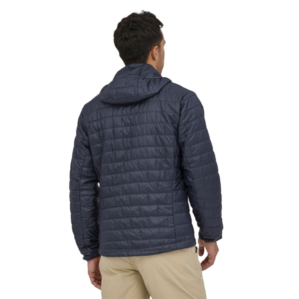 Person wearing the smolder blue Patagonia Men's Fitz Roy Trout Nano Puff Hoody and tan pants on a white background.