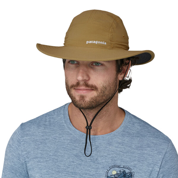 A Patagonia Quandary Brimmer hat in a tan color with a wide brim and an adjustable chin strap, on a white background.