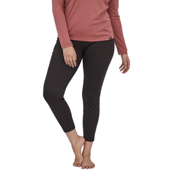 Person wearing the black Patagonia Women's Capilene Midweight Bottoms on a white background.