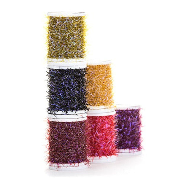 Stacked spools of Textreme Brill UV fly tying material on a white background.